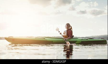 Kajak, Weltraum und Frau auf dem See mit Boot, Freizeit-Hobby und Sommer-Erkundung im Urlaub. Flare, Ruder oder weibliche Person auf dem Fluss mit Kanu Stockfoto