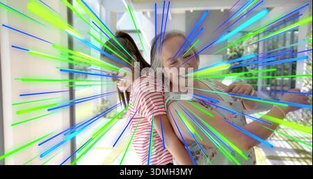 Lächelnde Mutter und Tochter, die sich auf der Veranda beugen, in floralem Oberteil und gestreiftem T-Shirt, Neonstreifen Stockfoto