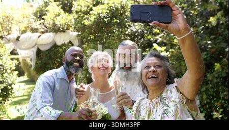 Lächelnde vier Erwachsene in leichten Hemden, die eine Brille hochheben und Selfie mit dem Smartphone im Garten machen Stockfoto