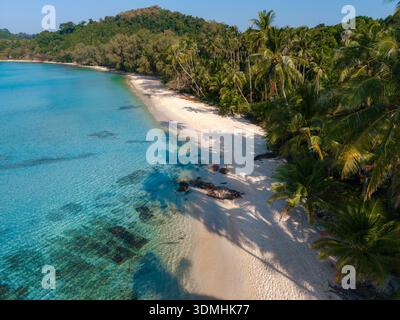 Erleben Sie die ruhige Schönheit des Takhian Beach in Koh Kood, Thailand, wo türkisfarbenes Wasser auf weichen weißen Sand trifft, umgeben von lebhaften Palmen und Stockfoto