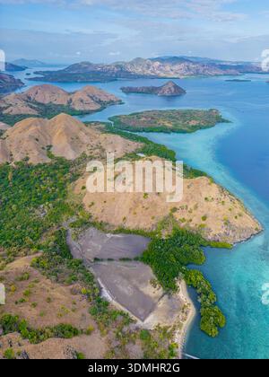 Bei einem atemberaubenden Blick aus der Luft auf den Komodo-Nationalpark in Indonesien zeigt sich türkisfarbenes Wasser mit üppigen Inseln in einem lebendigen Wandteppich der Natur Stockfoto
