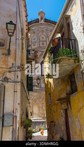 Eine enge Straße in der Altstadt von Ciambra in Monreale, Sizilien, Italien. 19. Bis Anfang des 20. Jahrhunderts mediterrane Volksarchitektur. Kathedrale Hintergrund Stockfoto