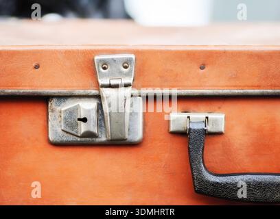 Vintage orange Koffer Nahaufnahme mit Metallverriegelung und Griff. Stockfoto