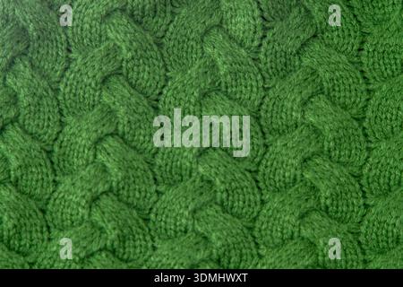 Grüner Zopfstrick Stoff Wollpullover Hintergrund. Stockfoto