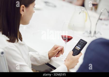Porträt von der Rückseite einer professionellen Sommelierin mit Rotwein und Analysefarbe, Nahaufnahme. Stockfoto
