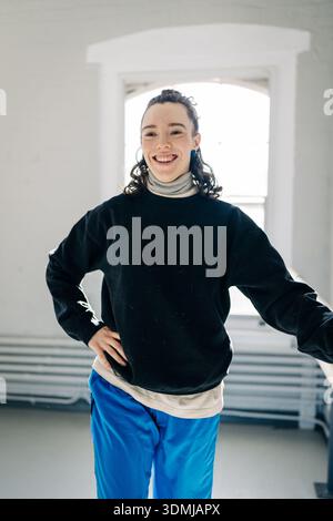 Junge Frau lächelt beiläufig im Studio Stockfoto