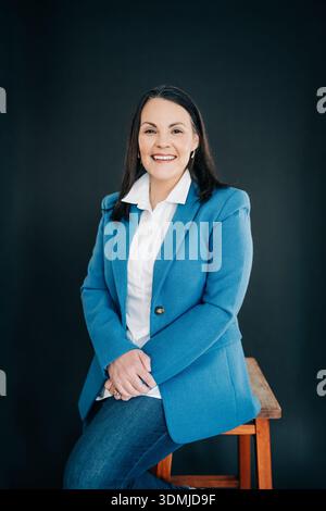 Professionelle Frau lächelt, posiert selbstbewusst im Studio Stockfoto