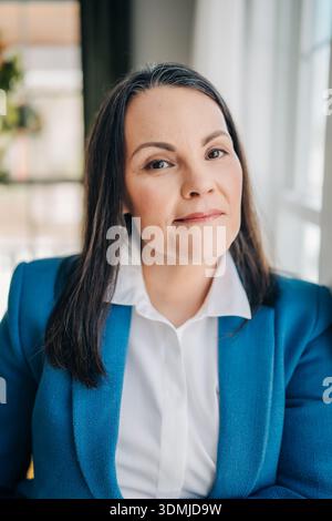 Selbstbewusste reife Frau mit blauem Business-Blazer Stockfoto