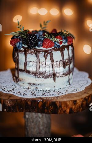 Einstöckiger Kuchen mit Schokolade, getropft mit Beeren Stockfoto