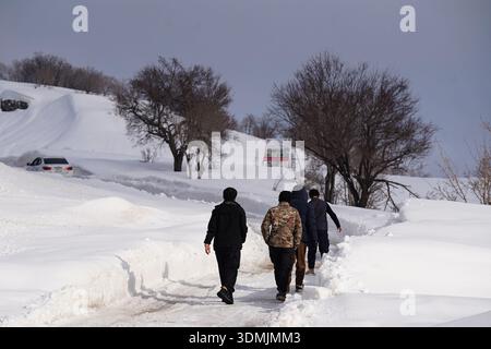 Duhok, Irak. Februar 2026. Die Menschen laufen auf einer schneebedeckten Bergstraße im Gara-Gebirge. Das Gara-Gebirge das höchste Gebirge erhebt sich etwa 2.151 Meter über dem Meeresspiegel und liegt etwa 60 Kilometer nördlich der Stadt in der Region Kurdistan. (Foto: Ismael Adnan/SOPA Images/SIPA USA) Credit: SIPA USA/Alamy Live News Stockfoto