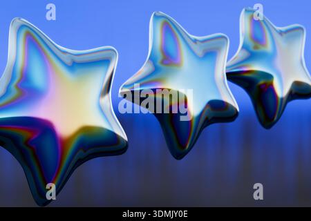 Drei glänzende sternförmige Ornamente mit schillernden Farben auf blauem Hintergrund. 3D-Rendering Stockfoto