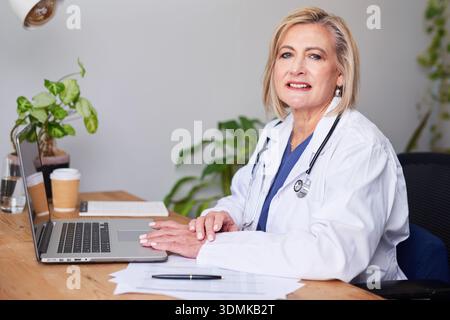 Professionelle Ärztin Am Schreibtisch Mit Laptop Im Büro, Bereit Zur Beratung Stockfoto