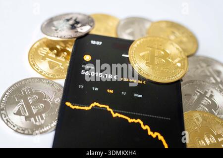 Fotoillustration: Der Kurs der Kryptowährung Bitcoin wird auf dem Display eines Smartphones mit fallendem Chart angezeigt, umgeben von Bitcoin-Münzen. Thema sind Kursschwankungen und Verluste auf dem Kryptomarkt. Aufnahme vom 06.02.2026 in Gummersbach, Deutschland. Foto-Illustration: Der Preis der Kryptowährung Bitcoin wird auf einem Smartphone-Bildschirm angezeigt, auf dem ein abnehmendes Diagramm angezeigt wird, umgeben von Bitcoin-Münzen. Das Konzept der Volatilität und Verluste auf dem Kryptowährungsmarkt. Foto vom 6. Februar 2026 in Gummersbach, Deutschland. *** Foto Abbildung der Preis der Kryptowährung Bitcoin ist Stockfoto