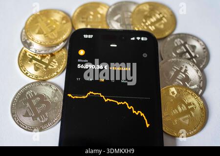Fotoillustration: Der Kurs der Kryptowährung Bitcoin wird auf dem Display eines Smartphones mit fallendem Chart angezeigt, umgeben von Bitcoin-Münzen. Thema sind Kursschwankungen und Verluste auf dem Kryptomarkt. Aufnahme vom 06.02.2026 in Gummersbach, Deutschland. Foto-Illustration: Der Preis der Kryptowährung Bitcoin wird auf einem Smartphone-Bildschirm angezeigt, auf dem ein abnehmendes Diagramm angezeigt wird, umgeben von Bitcoin-Münzen. Das Konzept der Volatilität und Verluste auf dem Kryptowährungsmarkt. Foto vom 6. Februar 2026 in Gummersbach, Deutschland. *** Foto Abbildung der Preis der Kryptowährung Bitcoin ist Stockfoto