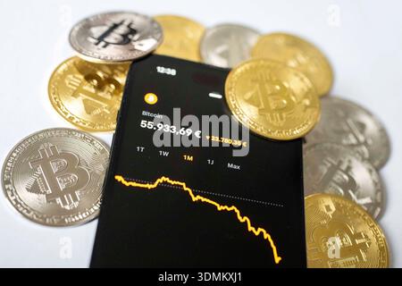 Fotoillustration: Der Kurs der Kryptowährung Bitcoin wird auf dem Display eines Smartphones mit fallendem Chart angezeigt, umgeben von Bitcoin-Münzen. Thema sind Kursschwankungen und Verluste auf dem Kryptomarkt. Aufnahme vom 06.02.2026 in Gummersbach, Deutschland. Foto-Illustration: Der Preis der Kryptowährung Bitcoin wird auf einem Smartphone-Bildschirm angezeigt, auf dem ein abnehmendes Diagramm angezeigt wird, umgeben von Bitcoin-Münzen. Das Konzept der Volatilität und Verluste auf dem Kryptowährungsmarkt. Foto vom 6. Februar 2026 in Gummersbach, Deutschland. *** Foto Abbildung der Preis der Kryptowährung Bitcoin ist Stockfoto