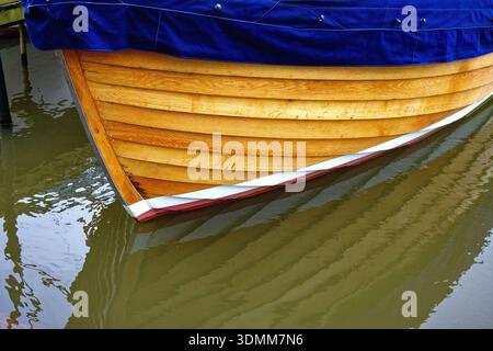 Nahaufnahme des hölzernen Rumpfes des Klinkers, das auf Wasser schwimmt und ein abstraktes Muster bildet Stockfoto