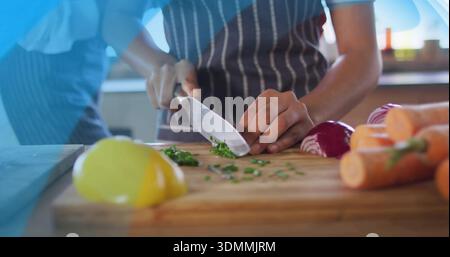 Hackende Frau mit gestreifter Schürze auf Schneidebrett in der Küche mit Kochmesser und Kräutern Stockfoto