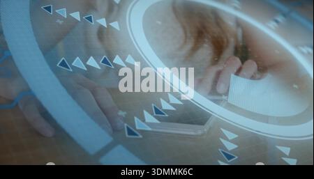 Weiße Karte in der Nähe des Mundes halten, Frau, die nach Telefon auf Holztisch greift, mit HUD-Überzug Stockfoto