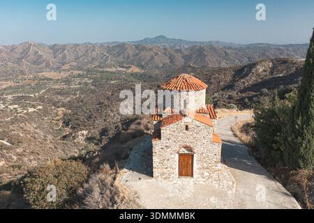 Alte Steinkapelle mit Blick auf die zerklüftete Landschaft von Pano Lefkara unter klarem Himmel. Pano Lefkara, Zypern Stockfoto