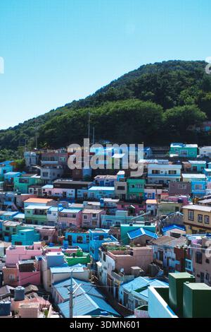 Eine vertikale Hochwinkelaufnahme mit den berühmten bunten Terrassenhäusern des Gamcheon Culture Village unter klarem blauen Himmel. Die lebendige Pastellfarbe Stockfoto
