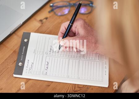 Business Planning Session Mit Daily Planner Und Stift Auf Holzschreibtisch Stockfoto