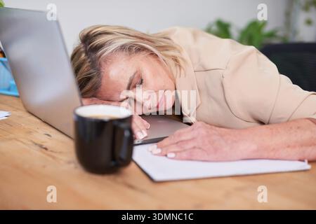 Müde Professional Schläft Am Schreibtisch Mit Laptop Und Kaffee Im Büro Stockfoto