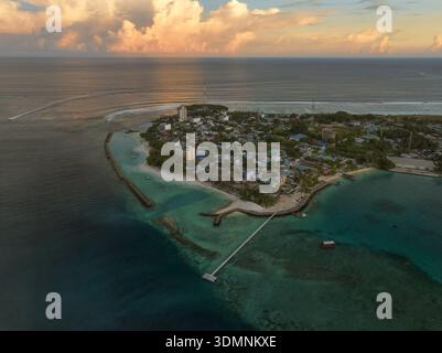 Aus der Vogelperspektive auf die lebhaften Gebäude der Insel und das türkisfarbene Wasser treffen auf den Horizont, Thulusdhoo, Kaafu Atoll, Malediven. Stockfoto