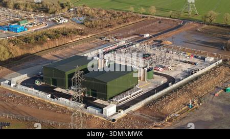 Aus der Vogelperspektive der modernen Walpole-Umspannstation National Grid mit ihren kontrastierenden grünen Gebäuden und dem komplexen Netz von Stromleitungen vor der Rückseite Stockfoto