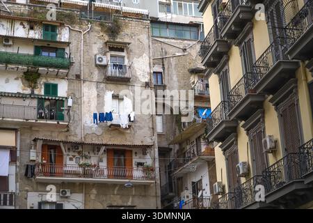 Fassade eines typischen Wohnhauses in Neapel, Neapel, Italien. Zeigt abfallenden Putz, externe Klimaanlagen und am Bügeleisen hängende Wäsche Stockfoto