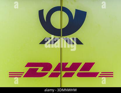 Das rot-gelbe DHL-Logo steht deutlich vor einem hellgelben Hintergrund und repräsentiert globale Versand- und Zustelldienste. Stockfoto