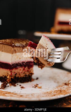 Gabel mit einem Hauch von schokoladigem Mousse-Kuchen und Beerengelee in der Nähe Stockfoto