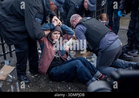London, Großbritannien. Februar 2026. Die Polizei benutzt elektrische Kettensägen, um einen Anti-Starmer-Protestler von einem Pappmaché-Bildnis von Keir Starmer zu trennen. Zwei junge Demonstranten von der Aktivistengruppe „TAKE BACK POWER“ klebten sich vor dem Parlament an ein Pappmaché-Bildnis von Keir Starmer. Sie mussten aus der Skulptur gesägt werden, bevor sie verhaftet wurden. Quelle: SOPA Images Limited/Alamy Live News Stockfoto