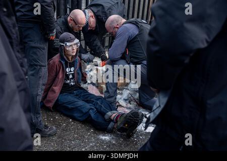 London, Großbritannien. Februar 2026. Die Polizei benutzt elektrische Kettensägen, um einen Anti-Starmer-Protestler von einem Pappmaché-Bildnis von Keir Starmer zu trennen. Zwei junge Demonstranten von der Aktivistengruppe „TAKE BACK POWER“ klebten sich vor dem Parlament an ein Pappmaché-Bildnis von Keir Starmer. Sie mussten aus der Skulptur gesägt werden, bevor sie verhaftet wurden. Quelle: SOPA Images Limited/Alamy Live News Stockfoto