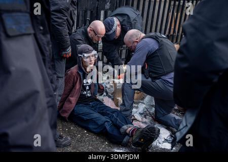 London, Großbritannien. Februar 2026. Die Polizei benutzt elektrische Kettensägen, um einen Anti-Starmer-Protestler von einem Pappmaché-Bildnis von Keir Starmer zu trennen. Zwei junge Demonstranten von der Aktivistengruppe „TAKE BACK POWER“ klebten sich vor dem Parlament an ein Pappmaché-Bildnis von Keir Starmer. Sie mussten aus der Skulptur gesägt werden, bevor sie verhaftet wurden. Quelle: SOPA Images Limited/Alamy Live News Stockfoto
