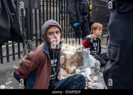 London, Großbritannien. Februar 2026. Die Polizei benutzt elektrische Kettensägen, um einen Anti-Starmer-Protestler von einem Pappmaché-Bildnis von Keir Starmer zu trennen. Zwei junge Demonstranten von der Aktivistengruppe „TAKE BACK POWER“ klebten sich vor dem Parlament an ein Pappmaché-Bildnis von Keir Starmer. Sie mussten aus der Skulptur gesägt werden, bevor sie verhaftet wurden. Quelle: SOPA Images Limited/Alamy Live News Stockfoto