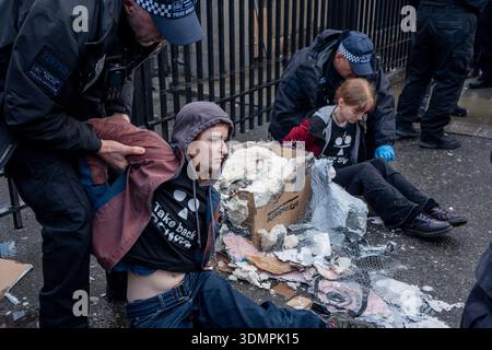 London, Großbritannien. Februar 2026. Die Polizei benutzt elektrische Kettensägen, um einen Anti-Starmer-Protestler von einem Pappmaché-Bildnis von Keir Starmer zu trennen. Zwei junge Demonstranten von der Aktivistengruppe „TAKE BACK POWER“ klebten sich vor dem Parlament an ein Pappmaché-Bildnis von Keir Starmer. Sie mussten aus der Skulptur gesägt werden, bevor sie verhaftet wurden. (Foto: Lab Mo/SOPA Images/SIPA USA) Credit: SIPA USA/Alamy Live News Stockfoto
