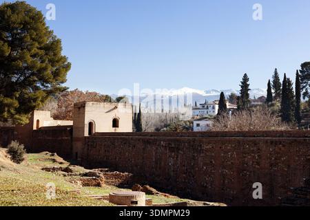 Festungsmauern und Türme am Alhambra-Komplex in Granada, Spanien, mit den Bergen der Sierra Nevada in der Ferne. Stockfoto