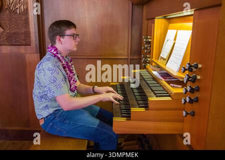 Ein Organist tritt während eines Gottesdienstes in der Waiokeola Congregational Church in Kahala, Honolulu, Hawaii auf. Der Musiker sitzt in einer Orga Stockfoto