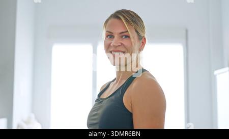 Frau lächelt nach dem Fitnesstraining zu Hause Stockfoto