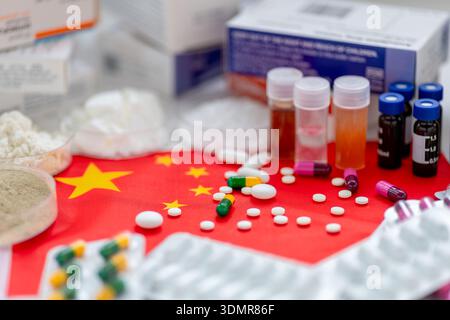 Arzneimittelpulver und flüssige Inhaltsstoffe und verschiedene lose und verpackte Medizin auf der Flagge Chinas. Eine China Pharmazie Wissenschaft, Produktion conc Stockfoto