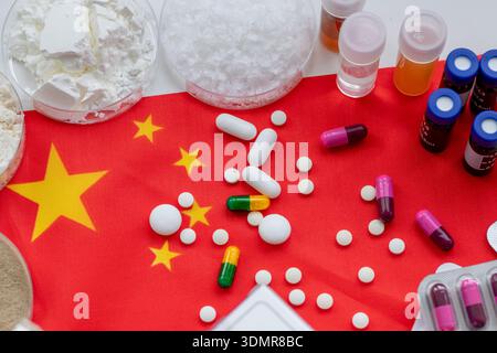 Ein chinesisches Arzneimittelherstellungs-, Arzneimittelkonzept mit Nahaufnahme von Arzneimittelgrundstoffen in Tabletts und verschiedenen losen und verpackten Tabletten und Stockfoto