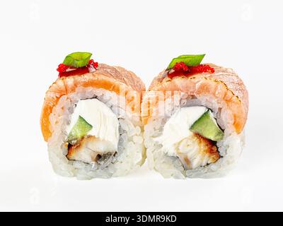 Eine Nahaufnahme von zwei japanischen Uramaki-Sushi-Brötchen mit gebratenem Lachs, Aal, Frischkäse, Gurke. Garniert mit rotem Tobiko-Reh. Saubere, minimalistische Komposition Stockfoto