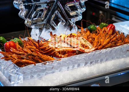 Fisch und Meeresfrüchte wie frische Garnelen und Jakobsmuscheln auf Eisschnitzerei, Fokus selektiv Stockfoto
