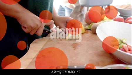 Schneidende Frau mit dunkelgrüner Spitze, die Zitrone auf Holzbrett in der Küche mit Stahlmesser schneidet Stockfoto