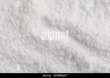 „Eine Nahaufnahme der Kristallkörner von Stevia zeigt eine unregelmäßige, ungleichmäßige Textur, bei der das Licht von den facettenreichen Körnern reflektiert wird.“ Stockfoto