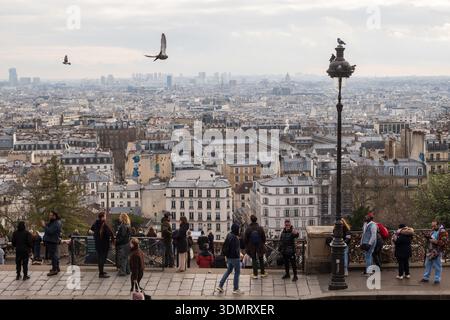 Paris, Frankreich - 26. Januar 2026: Allgemeiner Blick über Paris vom Basilika-Platz auf dem Montmartre-Hügel aus, mit Touristen im Vordergrund. Stockfoto