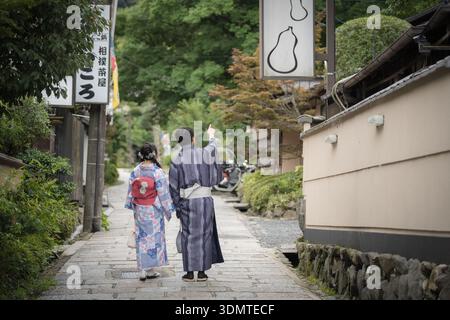 Ein Paar trägt Yukata und läuft auf der traditionellen gepflasterten Straße in Gion. Kyoto, Japan. Stockfoto