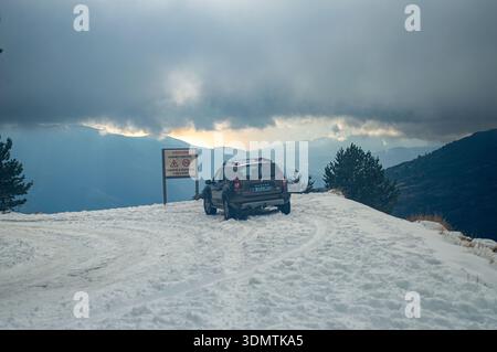 SIERRA NEVADA, SPANIEN - 30. DEZEMBER 2025: Ein Renault Duster fährt auf einer schneebedeckten Straße in Richtung Parking Hoya del Portillo und eröffnet den unberührten Winter Stockfoto