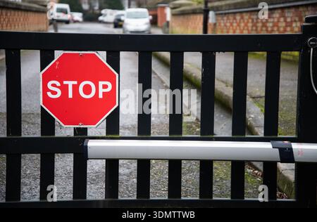 Rotes Stoppschild an einem Sicherheitstor, das den Zugang steuert und die Sicherheit, Verkehrsregelung und den eingeschränkten Zugang in einem städtischen Gebäude hervorhebt Stockfoto