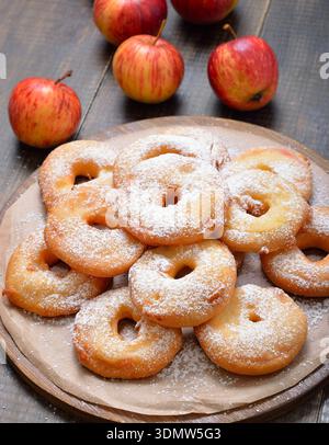 Apfelringe und frische Äpfel auf Holztisch Stockfoto